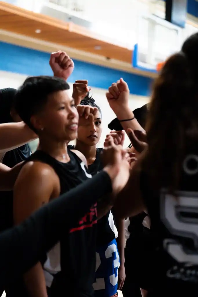 Athletes putting their hands in for a team huddle