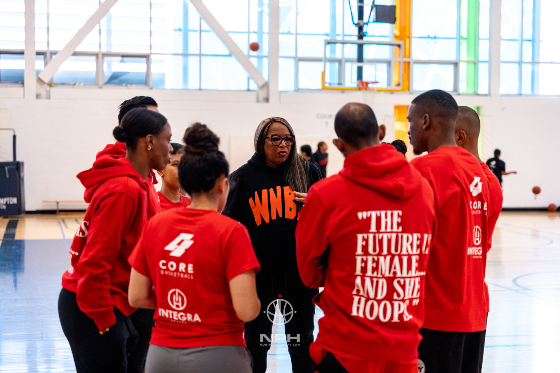 A coach leading a circle of young players during a Point Goddess camp